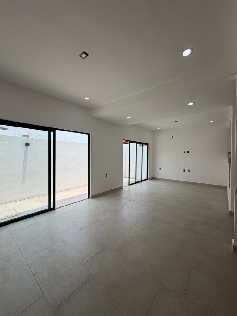 Sala comedor concepto abierto con ventanales de perfil negro y patio de iluminación en casa nueva Terranova Tuxtla